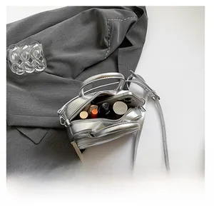 Detail showing the internal storage capacity of the silver crossbody bag for essentials