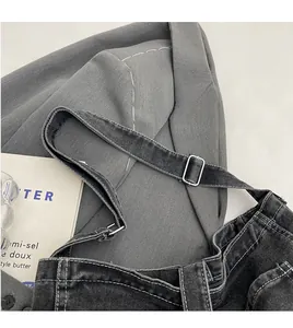 Detail eines verstellbaren Denim-Schultergurts mit Silberschnalle an der Tragetasche