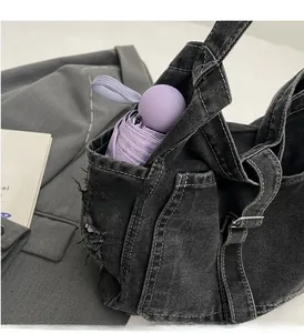 Detail of black denim tote side pocket showing storage capacity for a folding umbrella