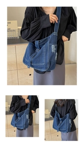 Detailed view of the distressed denim tote bag with frayed edges and contrast stitching