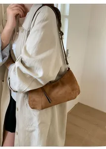 Gros plan détaillé du sac lune en daim marron avec fermeture éclair à franges sur le mannequin