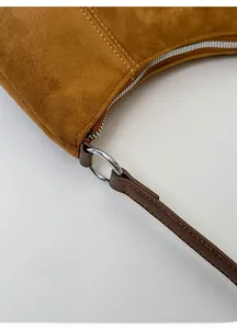 Détail de l'anneau métallique argenté reliant la bandoulière en cuir au sac hobo en daim