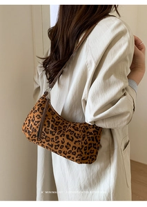 Gros plan d'un sac bandoulière en daim léopard avec bandoulière en cuir marron et zip