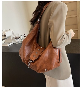 Detail view of brown pebbled leather hobo bag with silver star rivet and adjustable strap