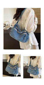 Dettaglio borsa a spalla in denim blu con chiusure lampo multiple e tracolla larga
