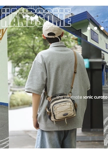 Detail of crossbody bag featuring utility bungee cords, multi-zipper pockets, and mesh side