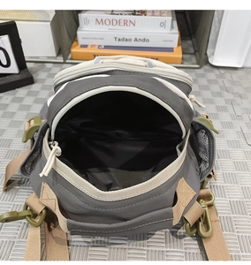 Macro view of multi-pocket tactical crossbody bag with spacious interior compartment