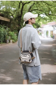 Outdoor crossbody bag detail showing criss-cross bungee cord and urban utility design