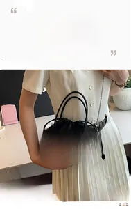 Detailed macro view of black bucket bag featuring silver rivet studs and drawstring closure