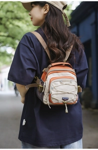 Detail of a lightweight orange and beige multi-purpose outdoor crossbody backpack for women