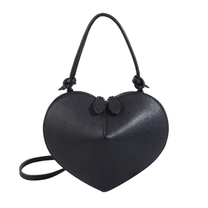 Detail of heart-shaped handbag with matte black leather texture and dual zipper closure