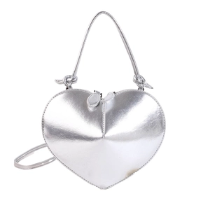 Macro detail of glossy silver heart-shaped handbag showing smooth metallic finish and zippers