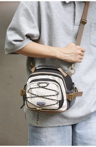 Cross-body hiking bag with elastic cord detail and multi-functional shoulder strap