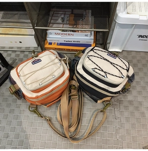 Detail of outdoor crossbody bags with elastic cord design and metallic hardware hooks