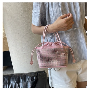Detail of pink rhinestone bucket bag with drawstring closure and silver chain strap