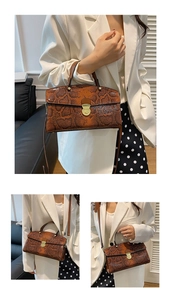Detailed view of brown snakeskin tote bag with gold buckle and crossbody strap