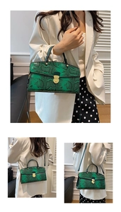 Detail of green faux snake pattern tote bag with metal clasp and slender shoulder strap