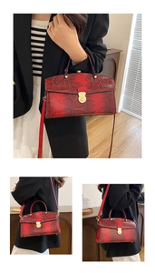 Detail view of red snakeskin tote bag with gold clasp and detachable shoulder strap