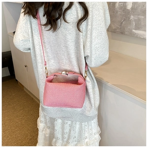 Detail of pink and white textured stripe woven bag on model for size perspective