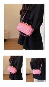 Detail view of pink crossbody bag with gold twist lock and adjustable shoulder strap