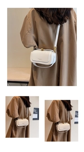 Detailed close-up of white leather crossbody bag featuring gold metal lock and flap design