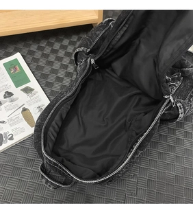 Top view of large capacity denim backpack showing black lining and dual silver zippers