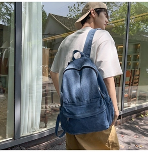 Detail view of denim backpack side profile with front pocket and adjustable straps