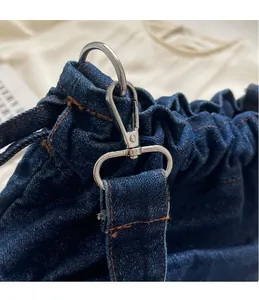 Detail einer Vintage-Jeanstasche mit silbernem Karabinerhaken und präziser Nahtverarbeitung