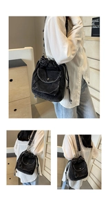 Detailansicht einer schwarzen Denim-Beuteltasche mit Kordelzug und praktischer Fronttasche