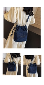 Detail der blauen Jeans-Beuteltasche mit Kordelzug und vorderer Druckknopftasche