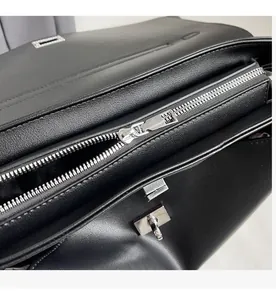 Detail view of the high-quality smooth silver zipper and metal clasp on black leather bag