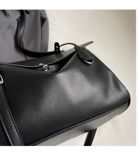 Close-up of black leather bag with silver twist-lock and fine grain texture detail