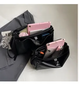 Detail view of black faux leather tote interior showing large capacity and multi-compartments