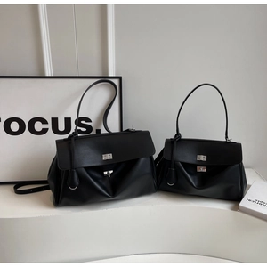 Detail of two black leather minimalist tote bags with silver turn-lock in various sizes