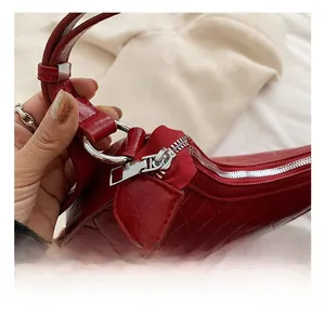 Close-up of polished silver hardware and red quilted leather texture on a shoulder bag