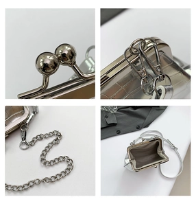 Silberne Metall-Kussverschluss-Taschendetail mit Metallrahmen, Kettengurt und Innenraum.