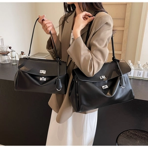 Comparison of black leather tote bags in two sizes with silver twist lock on table