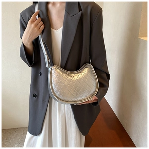 Detail of silver metallic quilted hobo bag with adjustable strap and diamond stitching
