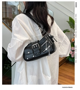 Détail du sac à bandoulière en cuir grainé noir avec boucles punk et rivets étoiles