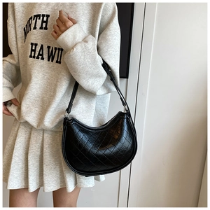 Close-up of black quilted leather hobo bag showing textured diamond stitching and strap