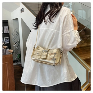 Détails du sac à bandoulière doré avec rivets, boucles et breloque en forme d'étoile