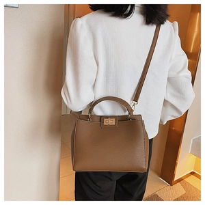Detail of brown lychee texture faux leather tote bag with a golden square twist lock