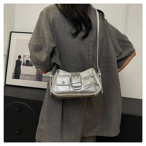 Détail du sac à bandoulière argenté métallisé avec clous et breloque étoile sur mannequin