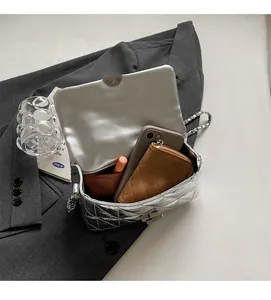 Internal view of silver quilted chain bag showing large capacity for phone and wallet