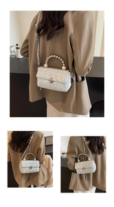 Detail of silver laser quilted bag with pearl handle and metal chain strap