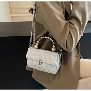 Detail of silver holographic quilted crossbody bag with pearl handle and chain strap