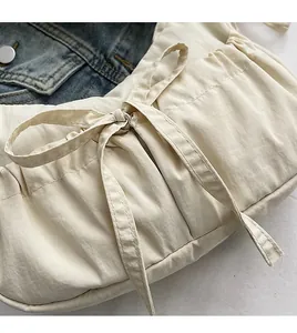 Close-up of pleated canvas bag with bow drawstring detail and soft fabric texture