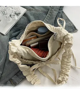 Spacious interior of a cream nylon cloud tote bag showing storage for daily essentials