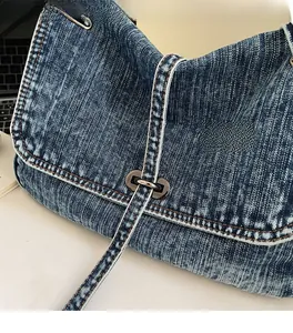 Detail of vintage washed denim fabric with metallic buckle and white stitching texture