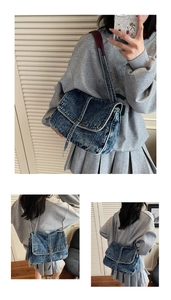 Detail of heavy washed denim tote bag with contrast stitching and metal buckle closure